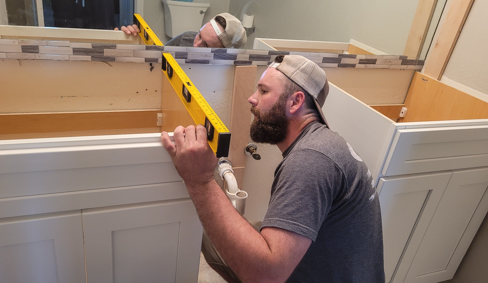 Remodel specialist making sure the cabinets are installed properly in bathroom.